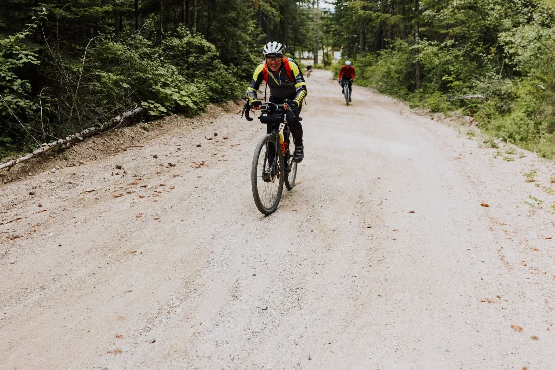Cyklist på en grusväg i skogen